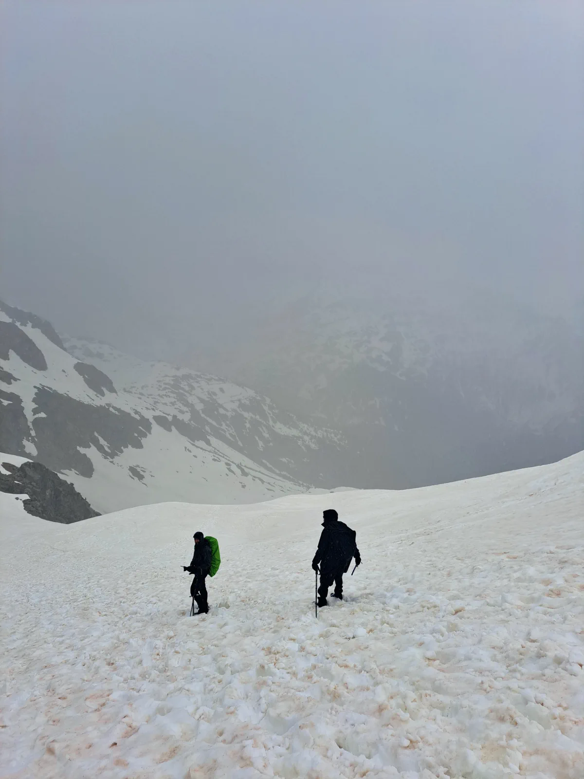 Dos integrantes progresan por la nieve con visibilidad reducida