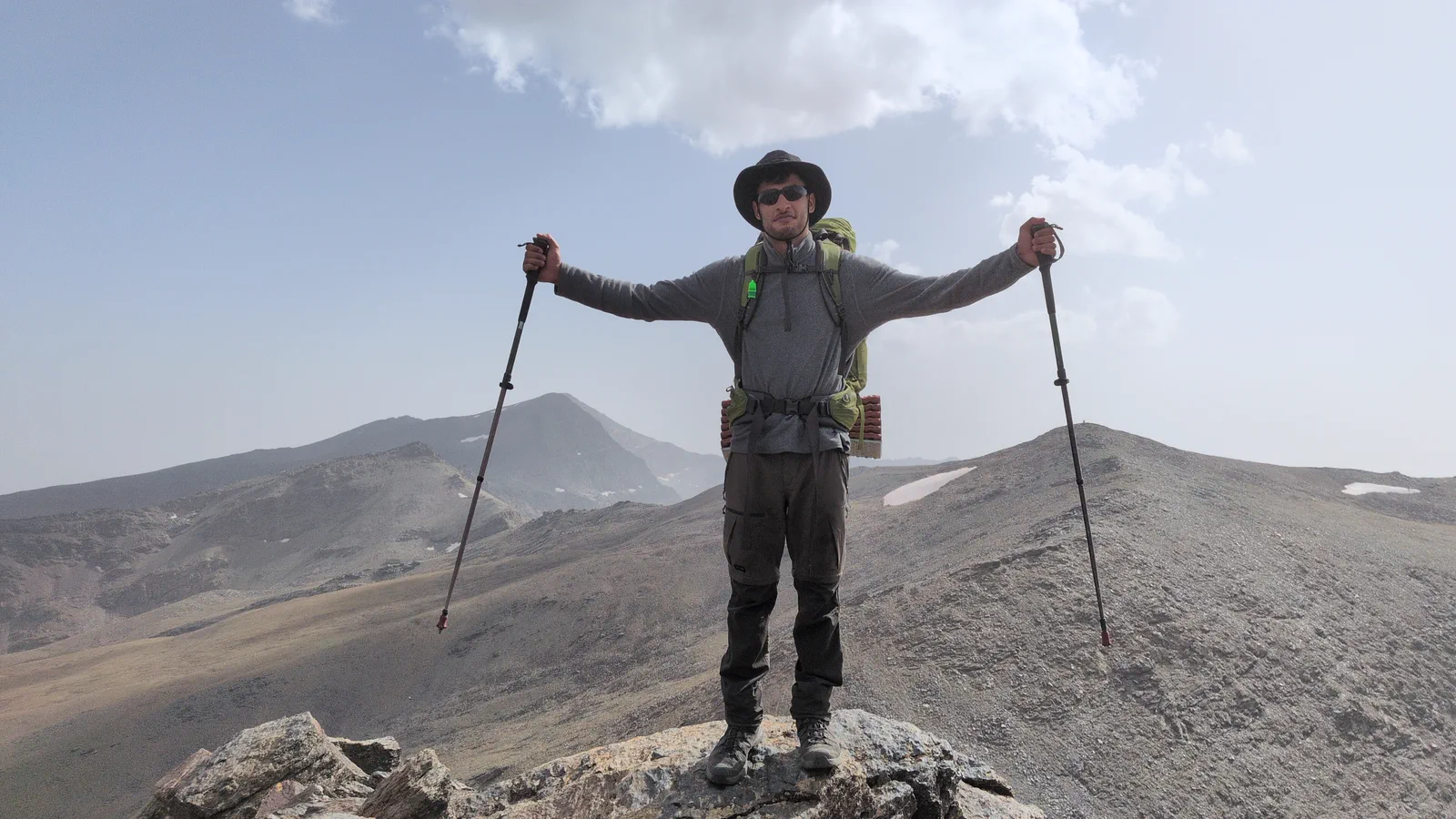 Un montañero contempla Sierra Nevada desde una cumbre rocosa