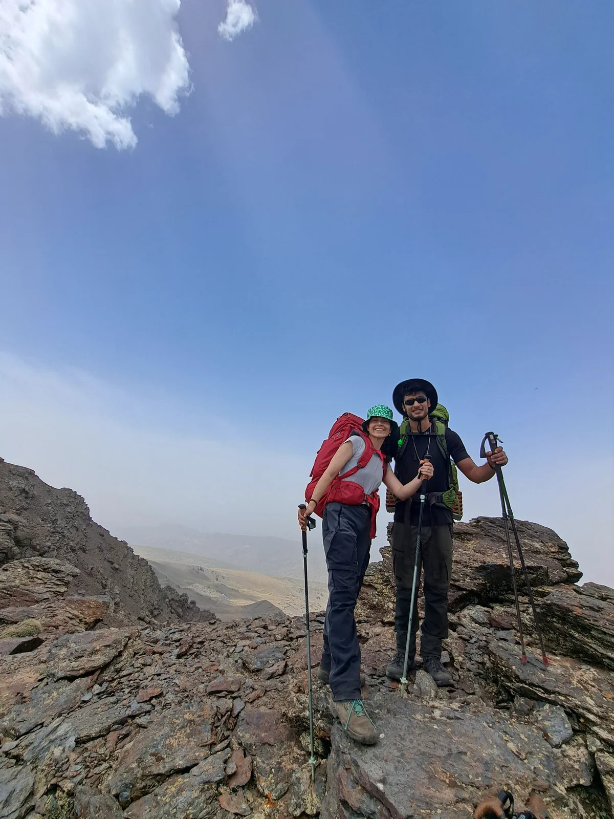 Dos integrantes del grupo con mochilas en terreno de alta montaña
