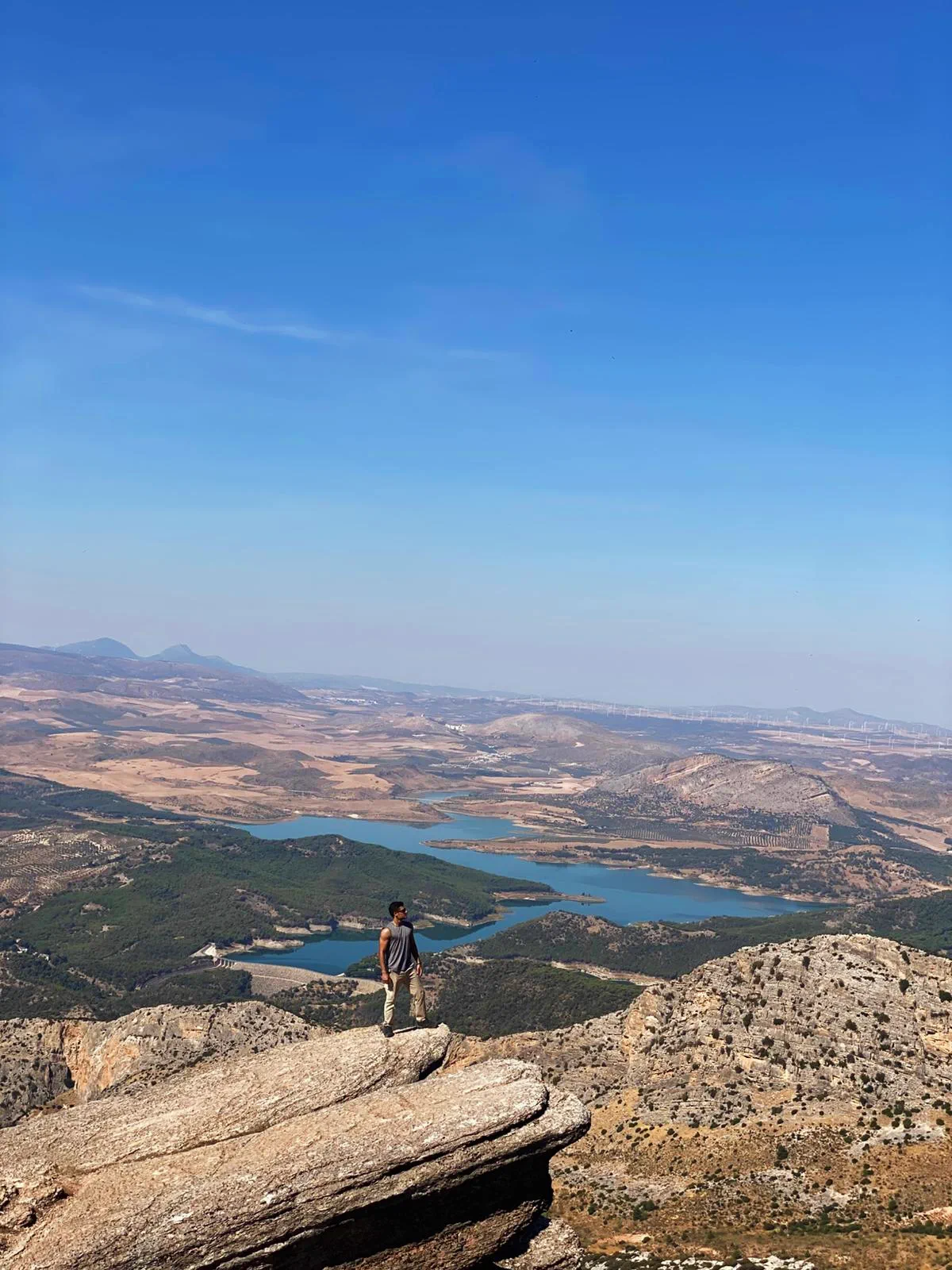 Bauti de pie sobre el Púlpito con los embalses de El Chorro al fondo
