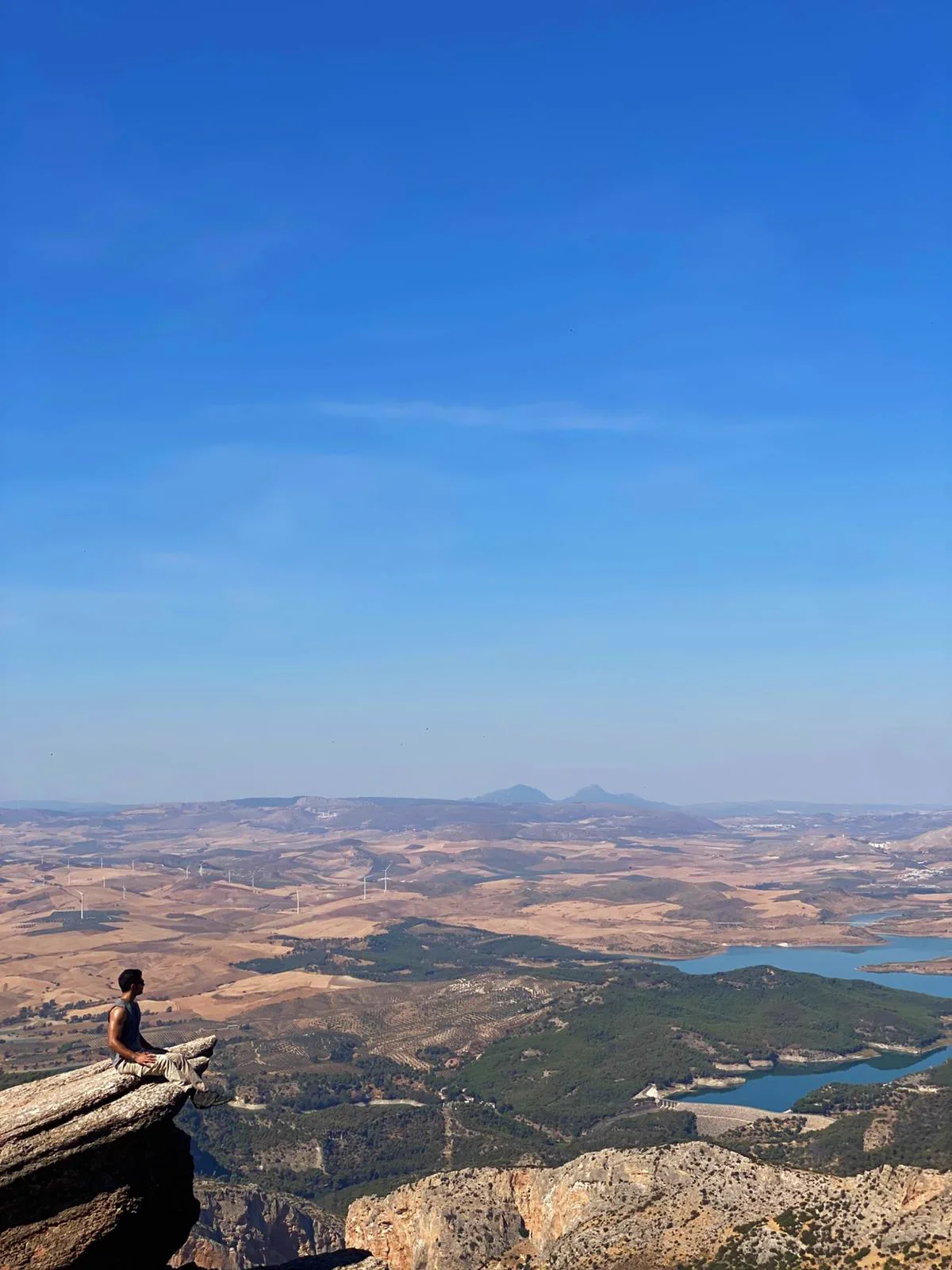 Bauti sentado en la punta del Púlpito sobre el paisaje de El Chorro