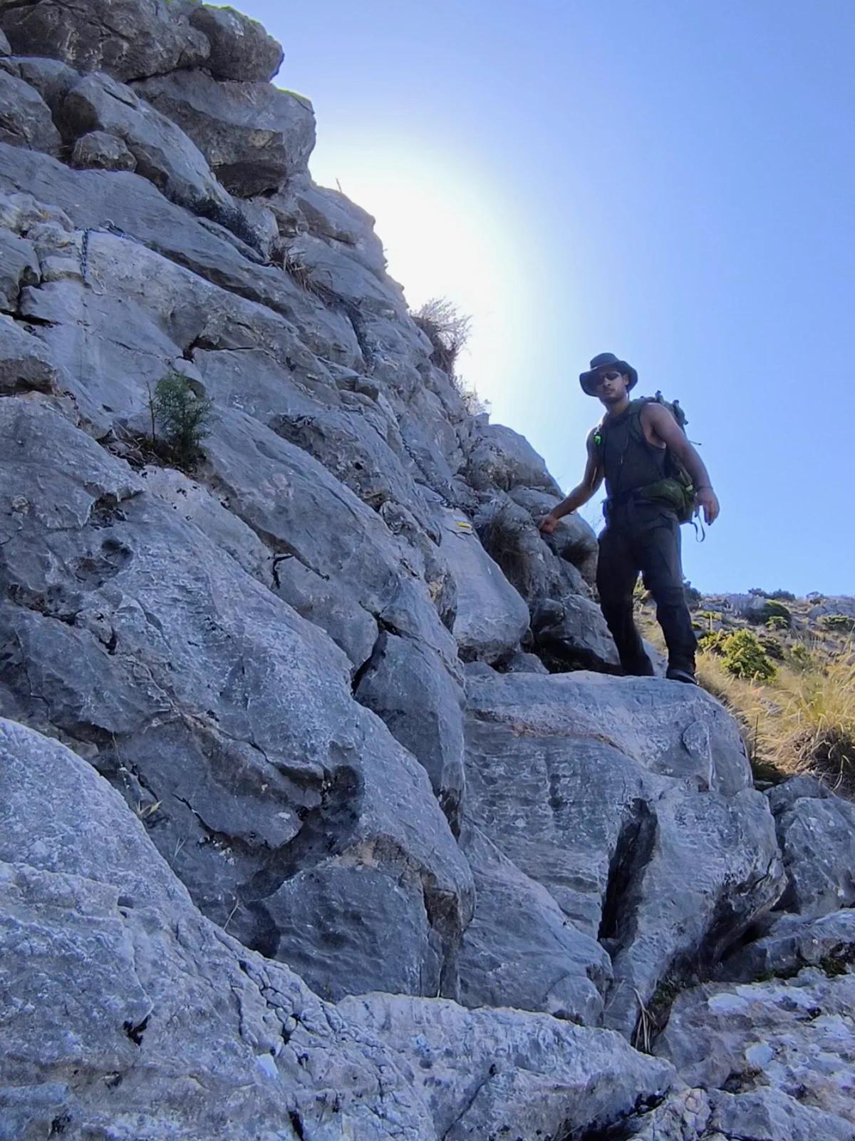 Senderista asciende por el terreno calizo de Sierra Blanca hacia el Pico La Concha