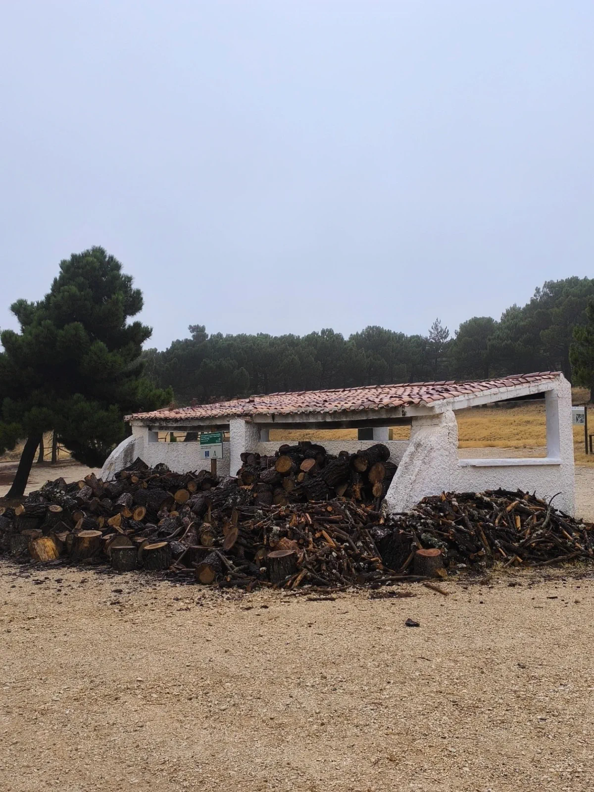 Refugio blanco y leña apilada en el área de Quejigales