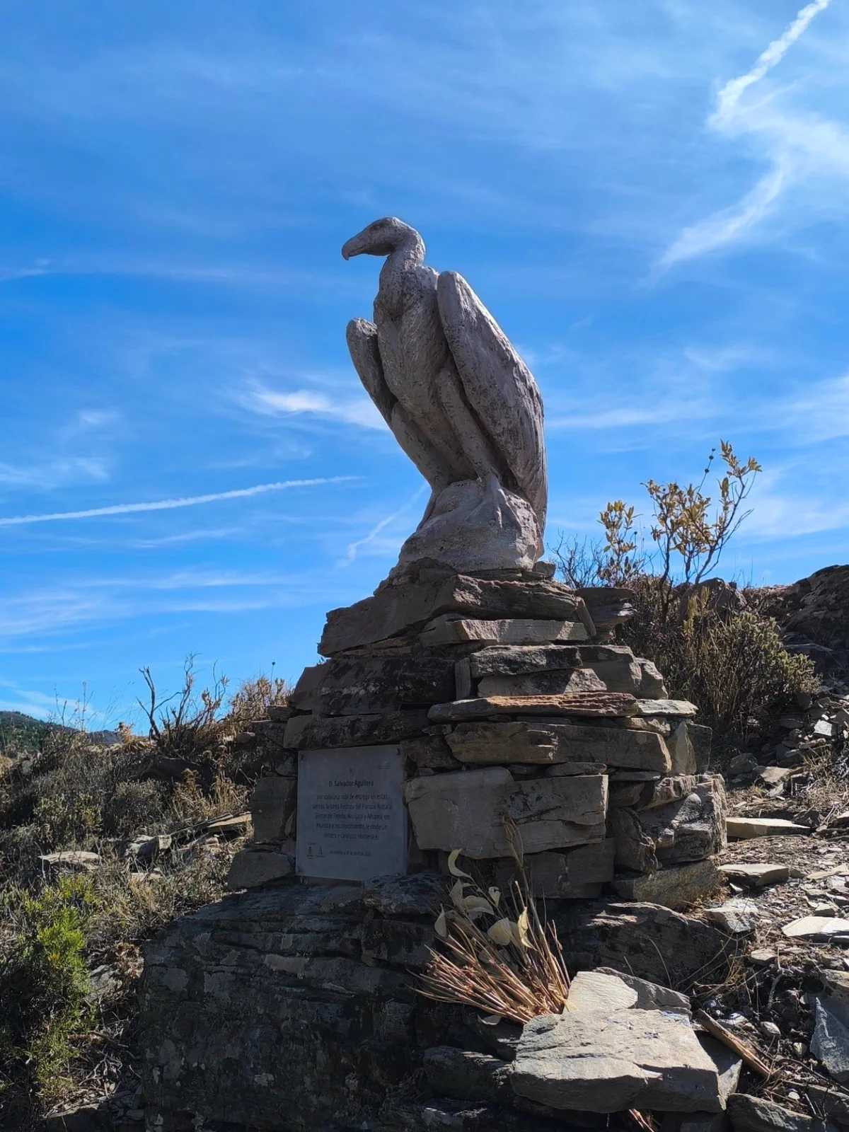 Escultura de un buitre sobre un pedestal de piedra en la ruta