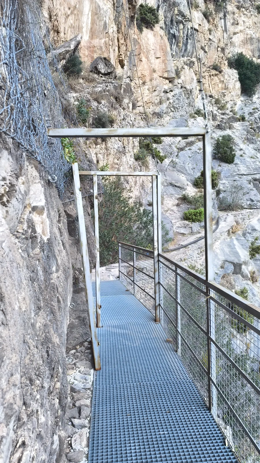 Pasarela metálica junto a una pared vertical de roca