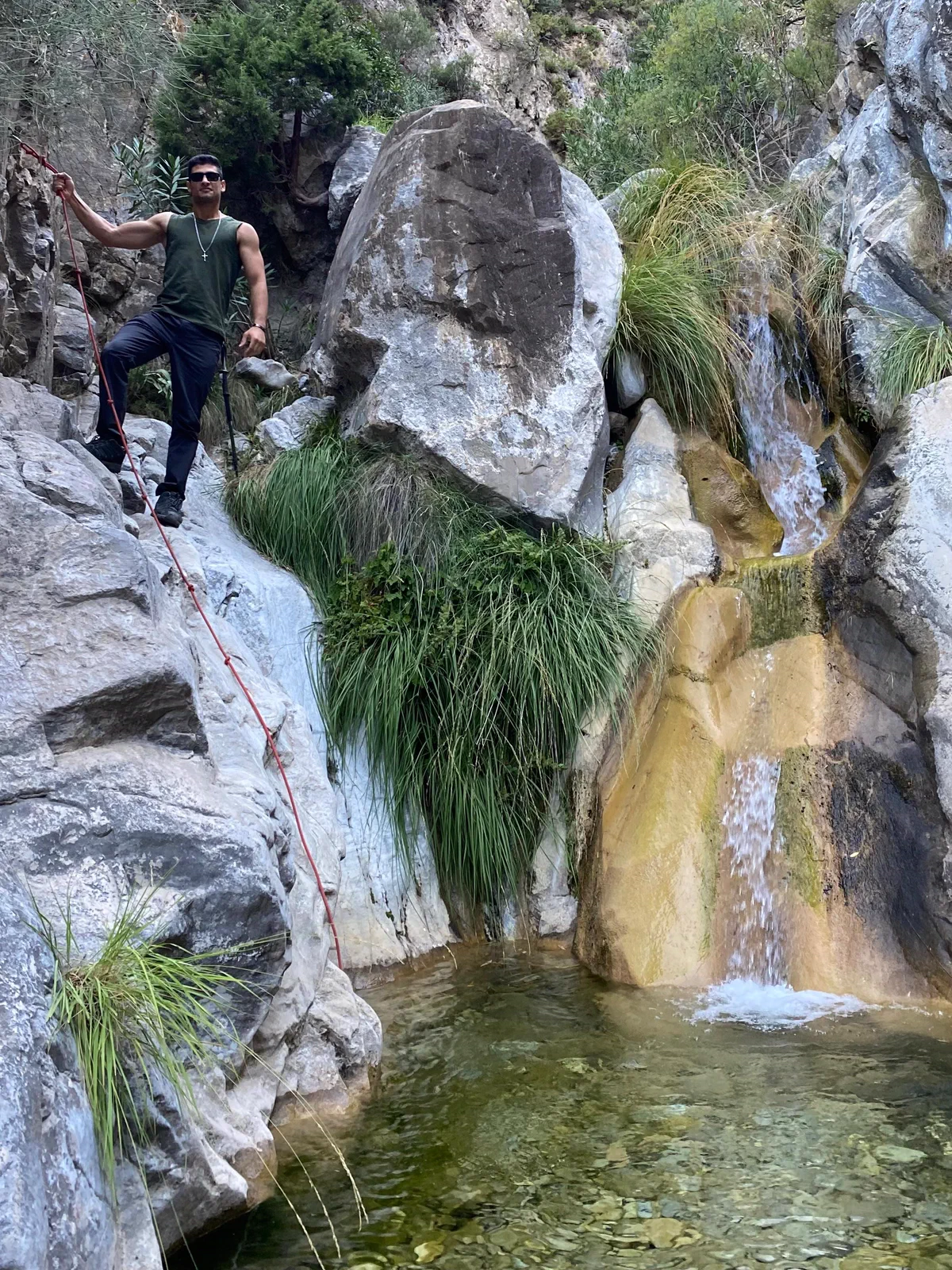 Senderista supera un paso de roca junto a la chorrera