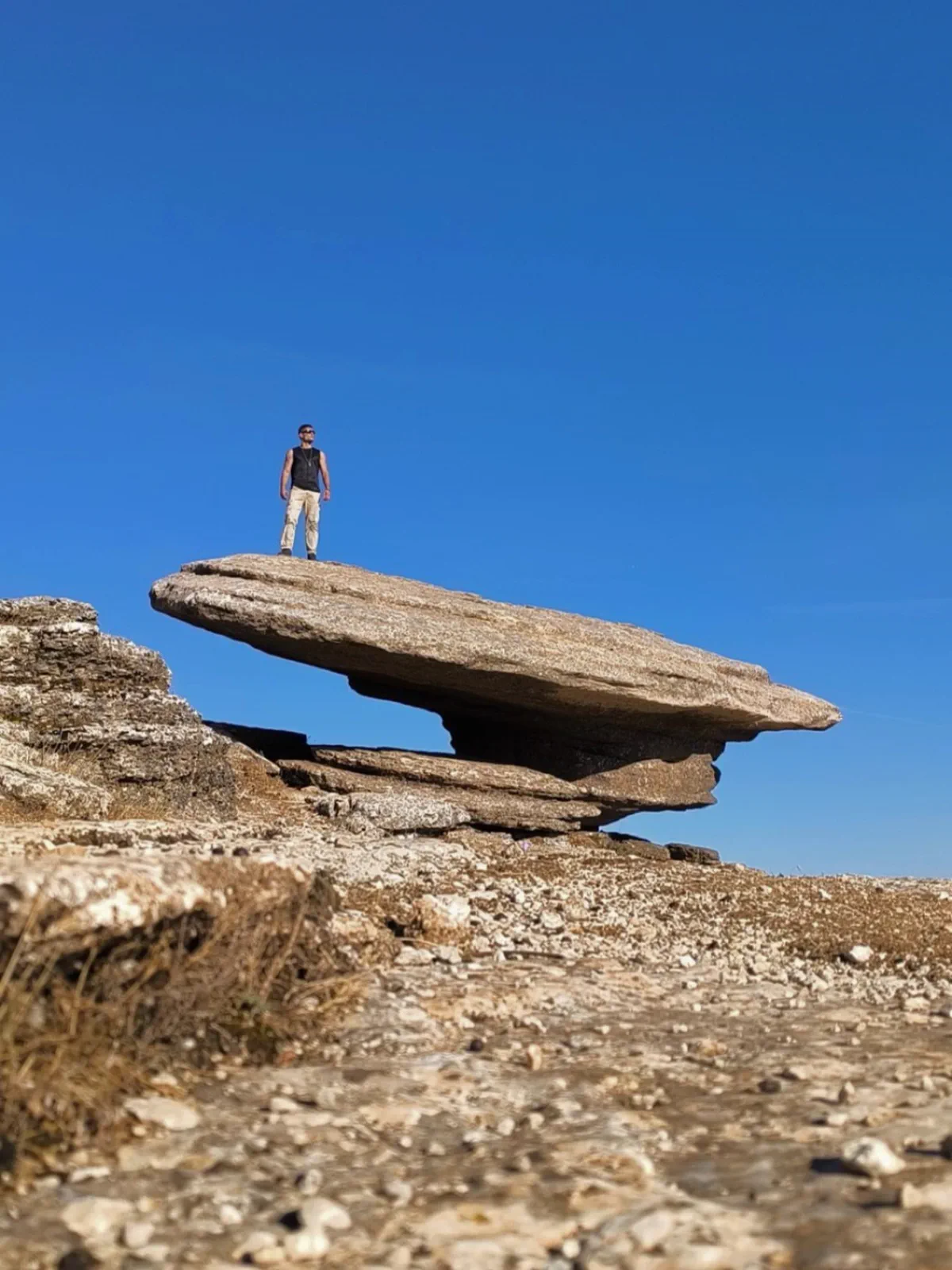 Bauti sobre una gran roca aparentemente en equilibrio en el Torcal de Antequera