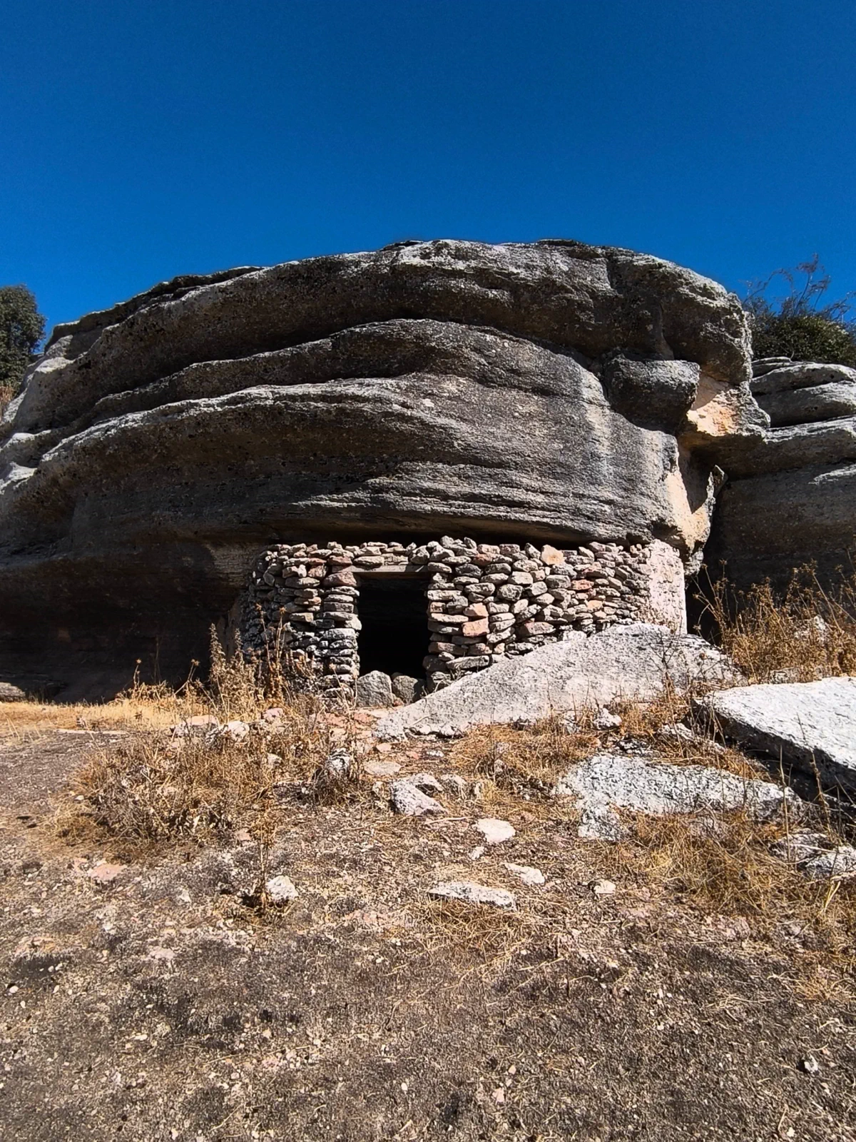 Pequeño refugio construido bajo una formación rocosa