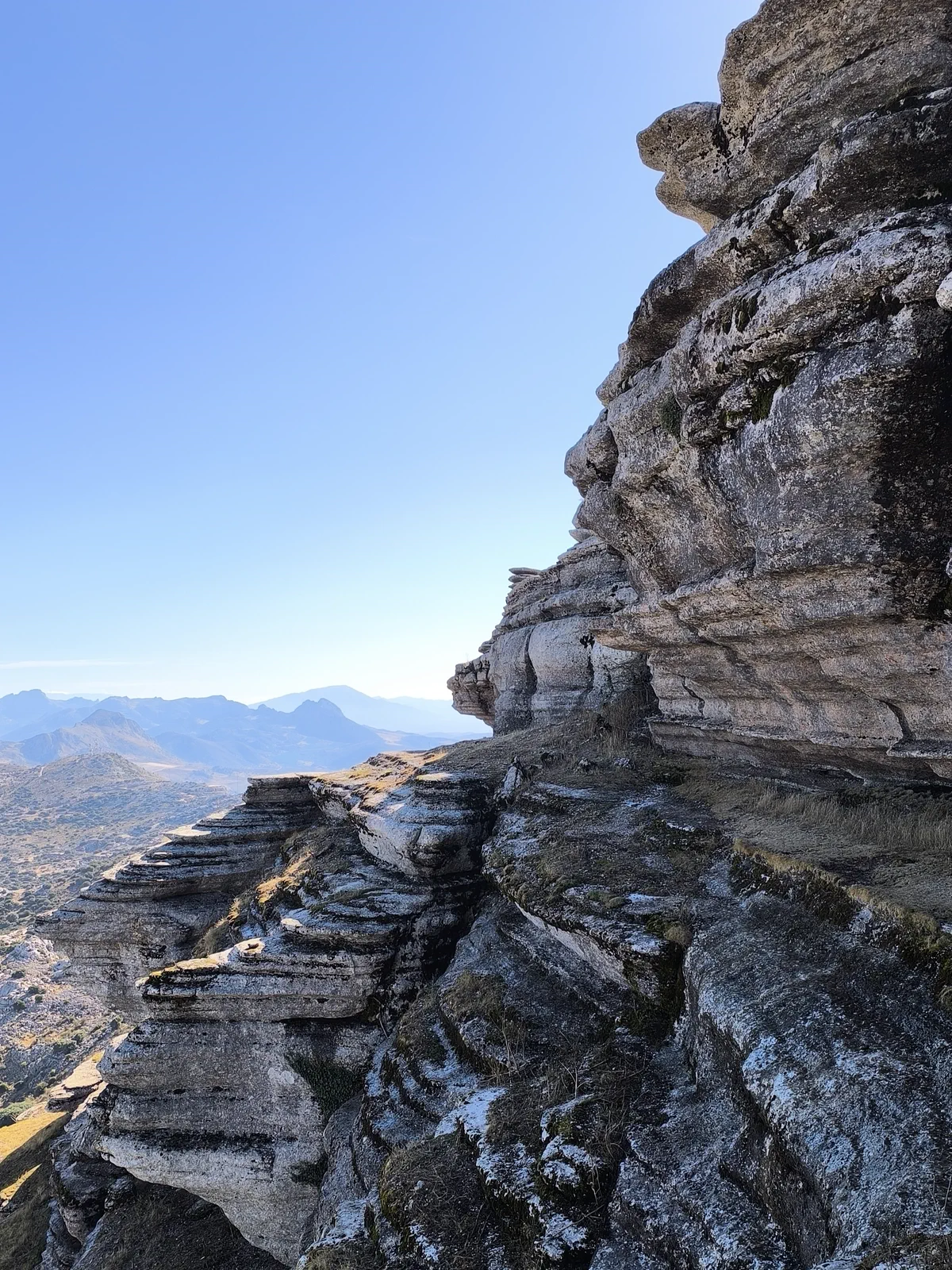Vista abierta del valle junto a una pared rocosa estratificada